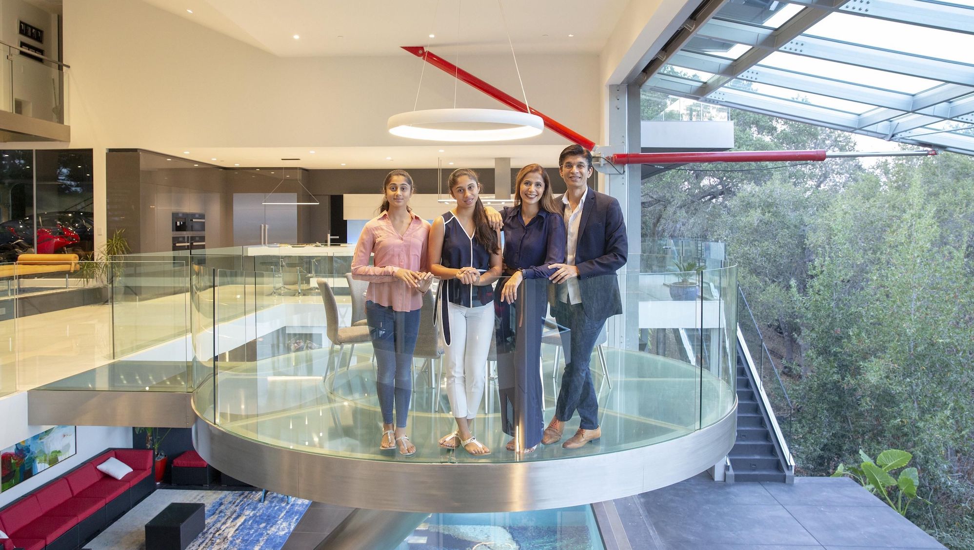 The family stands in a circular glass dining space inspired by the Starship Enterprise.