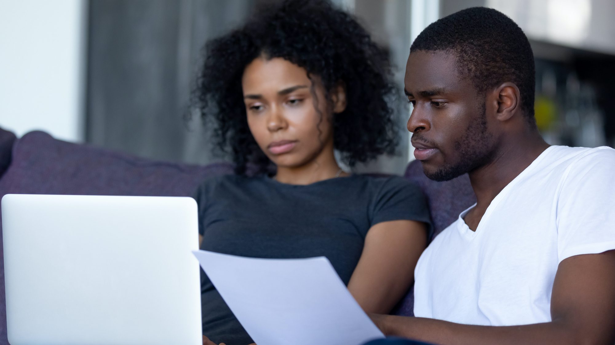 Black couple looking at mortgage bill