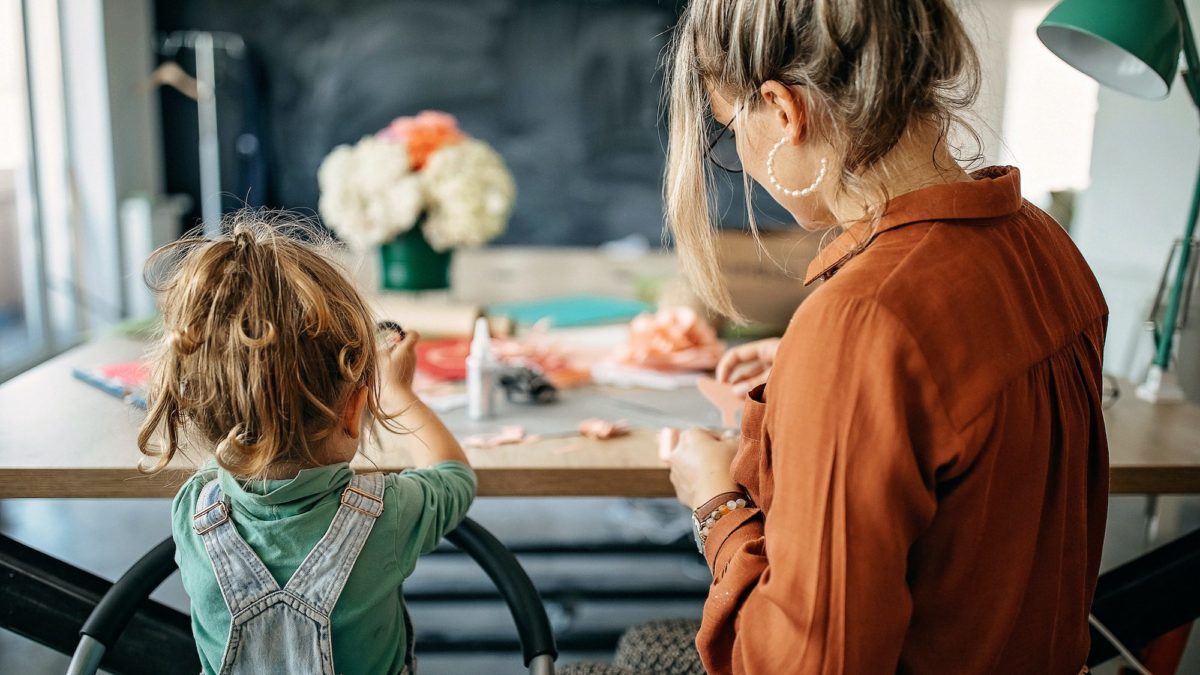 Mother and daughter making flowers of paper