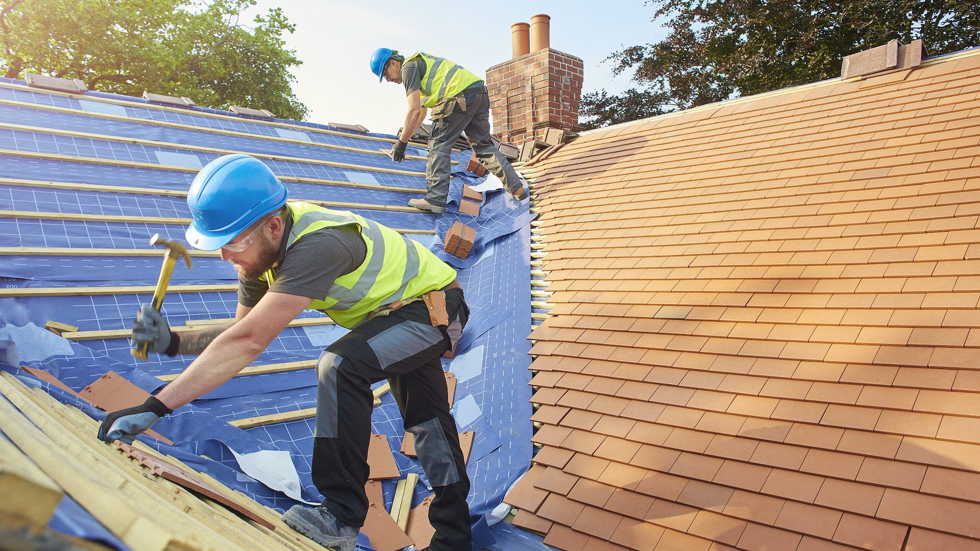 Roofers work on a house