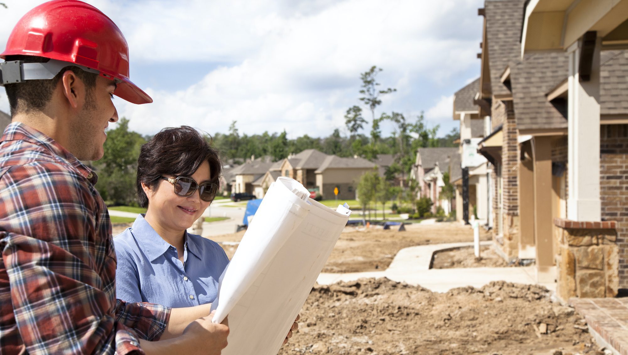 Builder meeting with woman at new home under construction