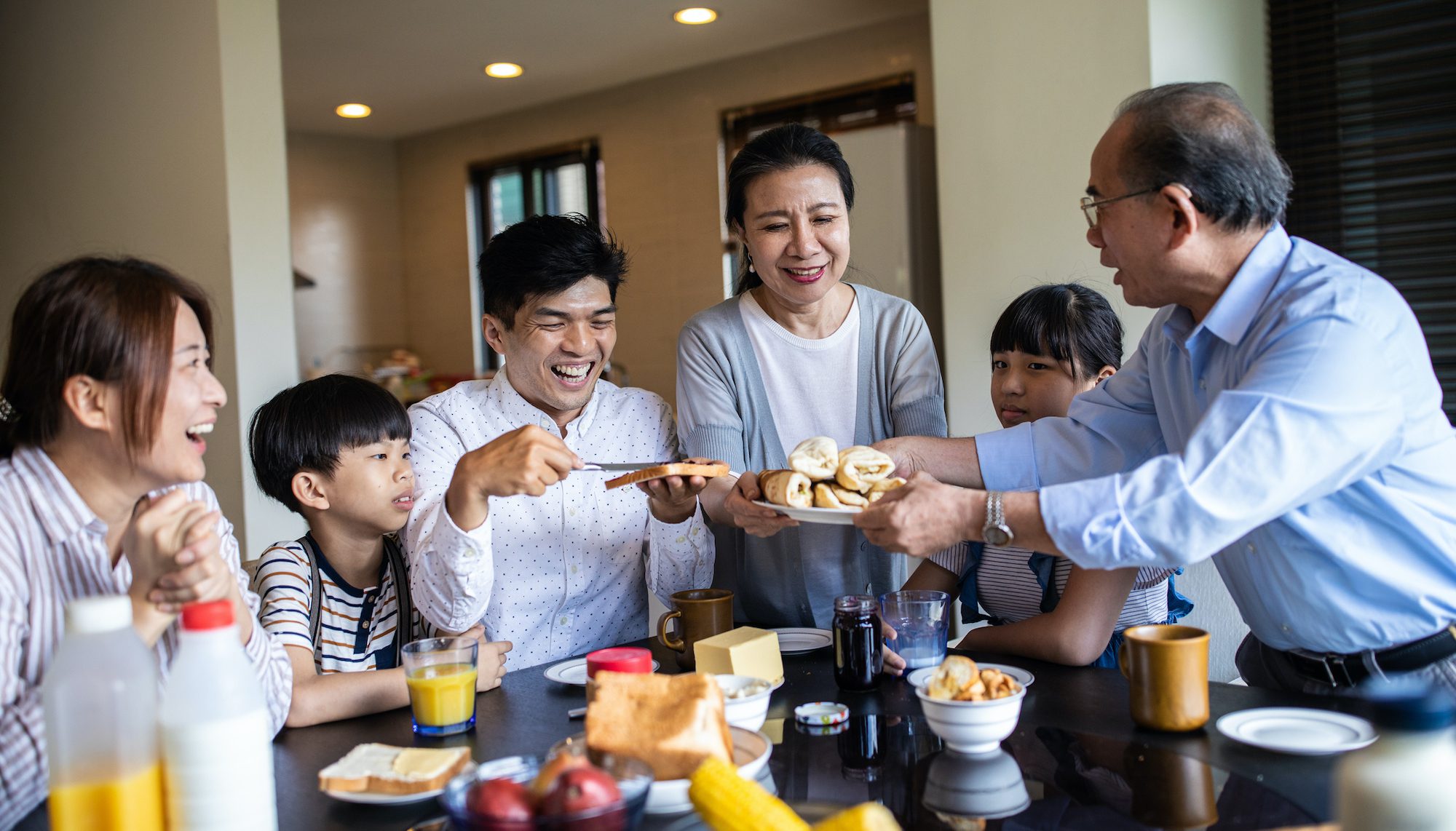 Extended family sharing breakfast; multigenerational housing