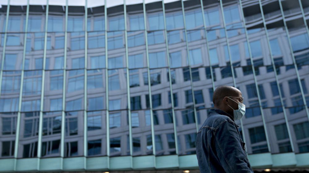 A pedestrian wearing a protective mask walks near the building that houses the Fannie Mae headquarters in Washington, DC.